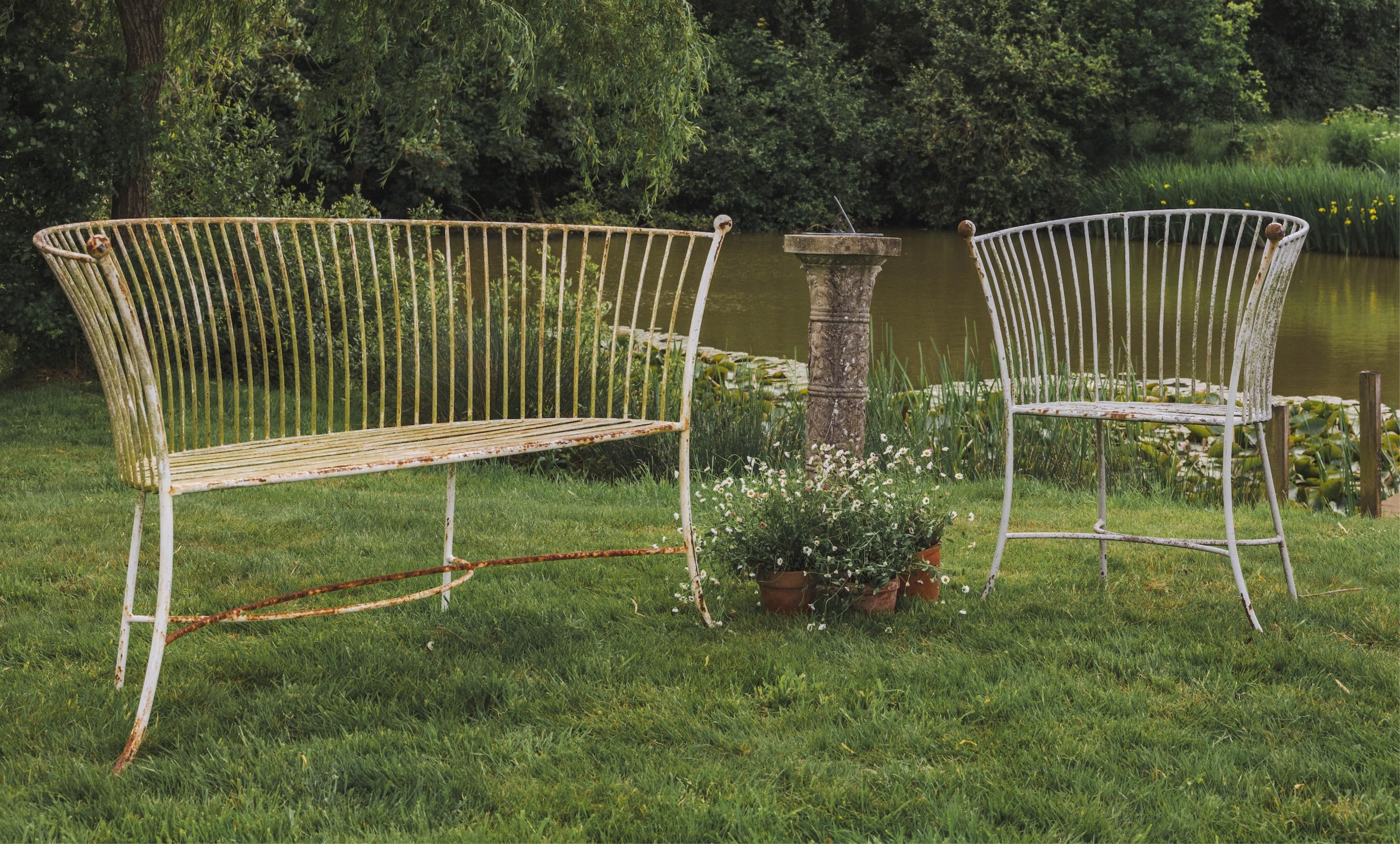 A painted wrought iron stick back garden bench, width 159cm, depth 55cm, height 91cm and a similar armchair